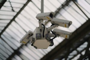 Four surveillance cameras next to each other at a train station in London.