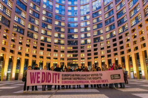 Liikumise "Minu hääl, minu valik" aktivistid Euroopa Parlamendi maja ees sildiga, kuhu on kirjutatud "Me tegime selle ära! Euroopa Parlament hääletas reproduktiivõiguste poolt. Euroopa Komisjon, nüüd on teie kord".
