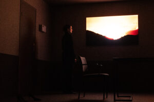 Tessa vaatab ekraani peal olevat päikeseloojangut.